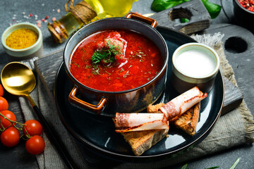 Homemade borsch with sour cream. Beet soup. Ukrainian cuisine. Close up. On a dark stone background.