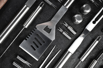 Fototapeta premium Barbecue and grill set Steel utensils. On a gray concrete background. Top view.