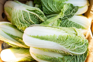 Green chinese cabbage piled together in cardboard box, close-up top view of fresh raw organic...