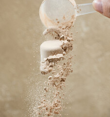 protein powder spills from measure scoop.  whey sports nutrition. dry mixture