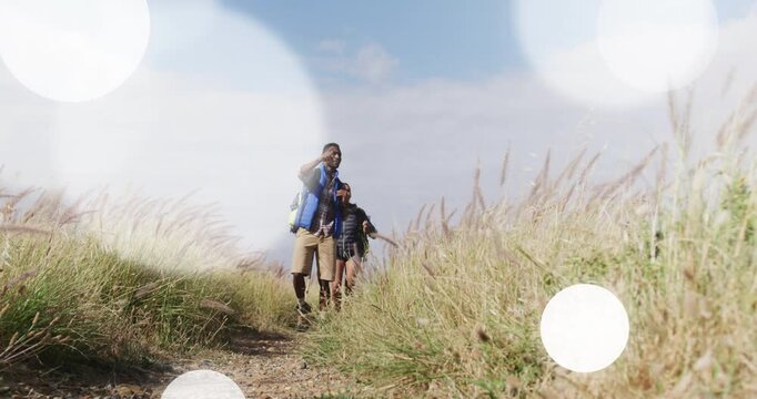 fitness hikers entering trail, descending, man pointing offscreen, flares drifting