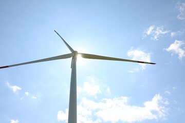 Modern wind turbine against blue sky, low angle view