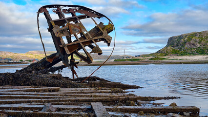 old abandoned sunken ship in the water at the ship cemetery wood pattern