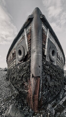 old abandoned sunken ship in the water at the ship cemetery wood pattern