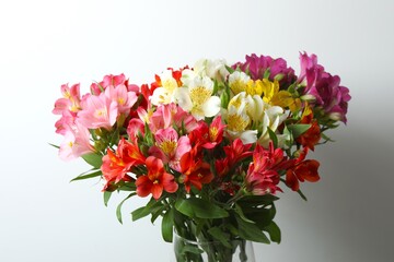 Beautiful alstroemeria flowers in a vase on the table, space for text 