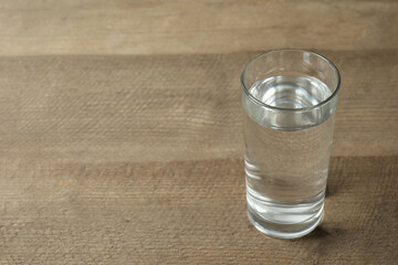 Glass with water on a wooden table. Drinking clear water 