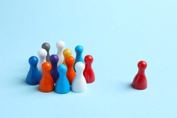 Group of colored pawns on a blue table. Concept of unity