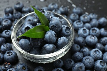 Glass bowl with fresh blueberries on the table