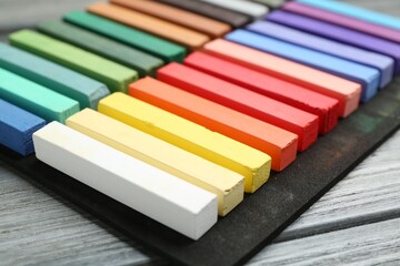 Colorful chalk pastels on wooden table, closeup