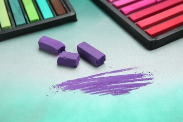 Colorful chalk pastels in trays on color background, closeup