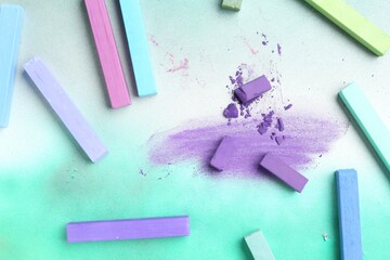 Colorful chalk pastels on color background, flat lay