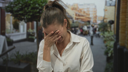 Young hispanic woman wearing white shirt with hand on chest and joyful smile in city street;...