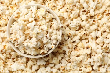 Tasty popcorn and bowl as background, closeup