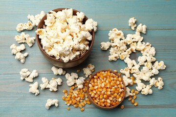 Tasty popcorn and corn kernels on blue wooden table, flat lay