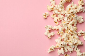 Tasty popcorn on pink background, flat lay. Space for text