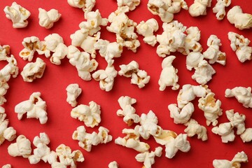 Tasty popcorn on red background, flat lay