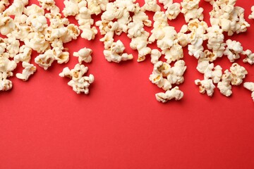 Tasty popcorn on red background, flat lay. Space for text