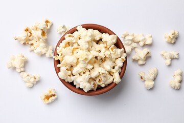 Tasty popcorn in bowl on white background, flat lay