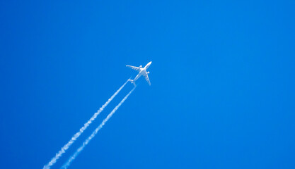 Passenger plane in the blue sky. A trace of the plane in the blue sky