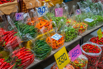 Colorful mixed chili varieties are packed in a clear plastic bag with a price tag, perfect to add...