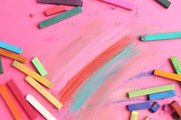 Many colorful chalk pastels on pink background, flat lay