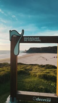 View of Golden light glows over Odeceixe Beach, Portugal, cliffs, sand, and Atlantic meeting point
