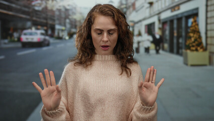 Woman meditating on urban street with closed eyes brings peace to city life in outdoor winter...