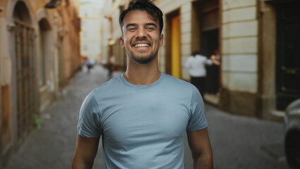 Young man smiling enthusiastically on an old town street, embodying joy and vitality in a vibrant outdoor environment.