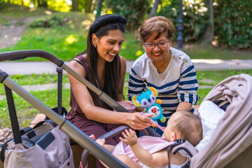 Latin family enjoying time together at park feeding baby girl