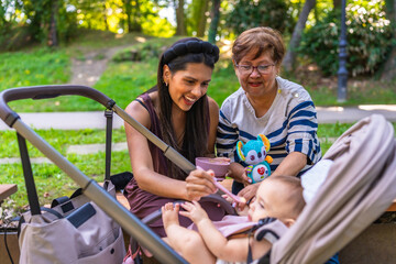 Latin family enjoying time together at park feeding baby girl