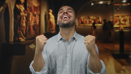 Man points thumb to chest in art gallery surrounded by paintings and sculptures on display; pride...
