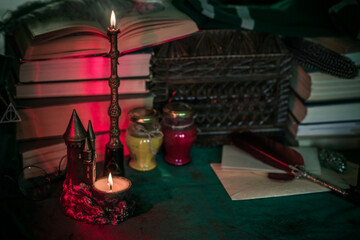 Dark style, books and other academia or school stuff on a table, autumn evening time 
