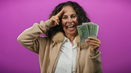 Middle-aged woman holding singapore dollars and saluting against a purple background exudes joy and...