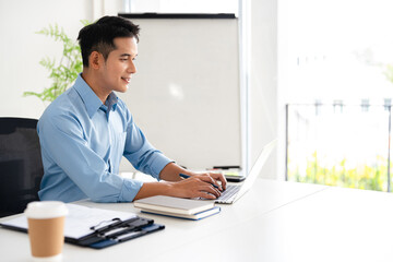 Happy professional business man company employee, young busy smiling male businessman entrepreneur or worker using laptop computer technology working at corporate office desk.