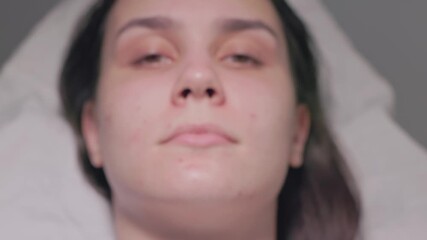 A woman examines her facial features and unique traits using a smartphone camera to capture details