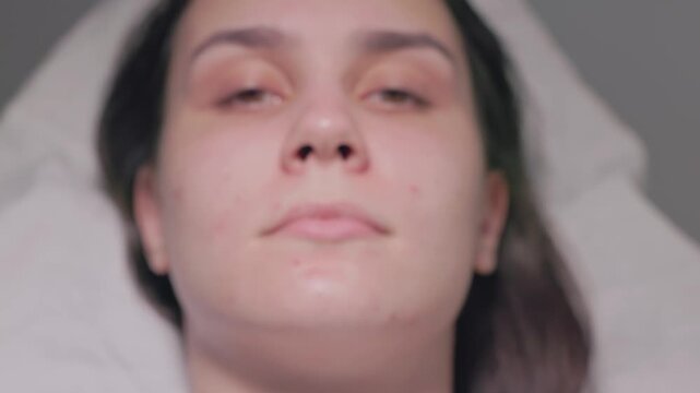 A woman examines her facial features and unique traits using a smartphone camera to capture details