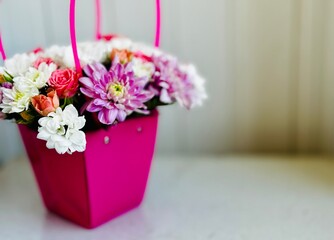 colorful flower arrangement in pink box