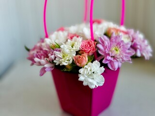 colorful flower arrangement in pink box