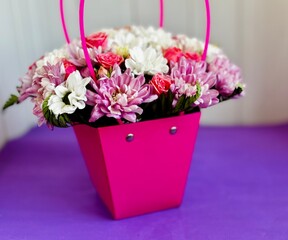 colorful flower arrangement in pink box
