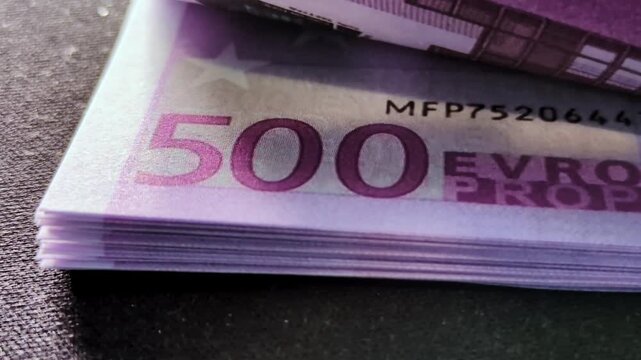 A stack of 500 euro bills sitting on a table.