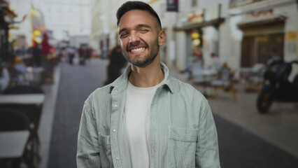 Hispanic man shouting with excitement on a bustling city street, his joyful expression highlighting...