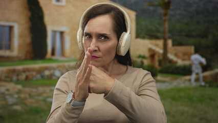 Young hispanic woman clenches fists in a fighting gesture on a cobblestone street; determination...