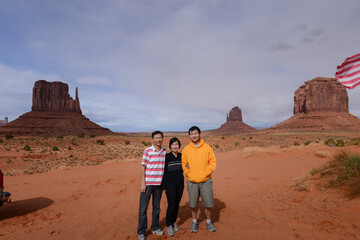 Tourists posing for photos in front of the Mittens and Merrick Butte. Monument Valley. Arizona. USA.