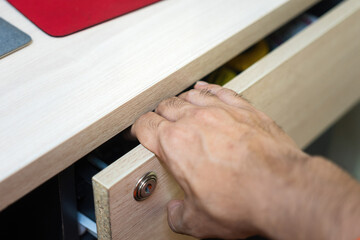 A human hand is pinched by drawer, cause hand and finger injury. Unsafe or hazard at workplace,...