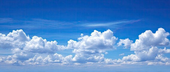 Wide shot of a vibrant blue sky dotted with fluffy white cumulus clouds (5)