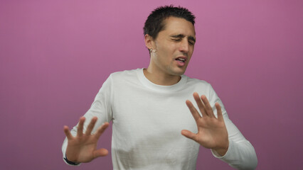 Young hispanic man wearing white shirt gestures against isolated pink background