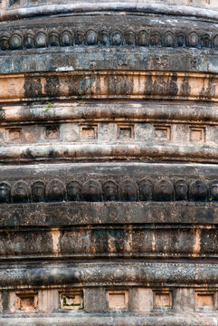 Closeup weathered ancient stupa bese with carved pattern and stains in temple