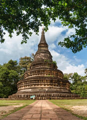 Ancient buddhist stupa of Wat Umong Suan Puthatham surrounded by lush green leaves in Thai temple at Chiang Mai, Thailand