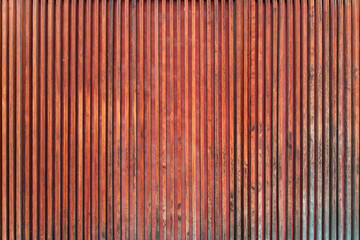 Red brown rustic vertical wooden wall panel with natural grain pattern