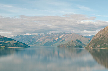 Serenity at Lake Wanaka: A tranquil view with mountain reflections on the still waters